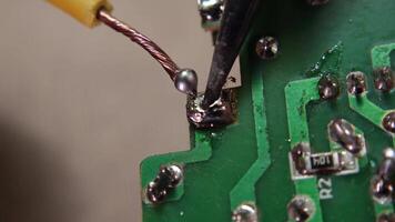 Soldering cables to electronic components as part of circuit board assembly. video