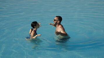 Young loving couple enjoying vacation in a pool on a warm summer day, dancing and laughing together. Concept vacation, travel, happiness. video