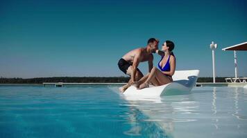 Young couple enjoying each other company in a pool on a hot vacation day, smiling and relaxed. Concept vacation, intimacy. video