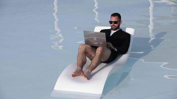 Man in suit working on laptop by pool video