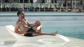 Man by pool with laptop video