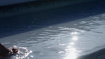 An unrecognizable woman walking on water in the pool on a hot sunny day. Concept summer relaxation, warmth, calm and leisure. video