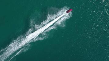 Top view of a single jet ski creating white foamy circles on deep green water. Concept summer adventure, tourism, water fun and active leisure. video