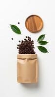 Coffee Beans Overflowing from Kraft Bag with Wooden Plate and Green Leaves on White Background photo