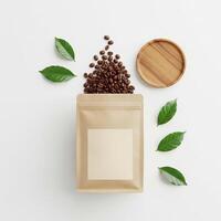Coffee Beans Overflowing from Kraft Bag with Green Leaves and Wooden Plate photo