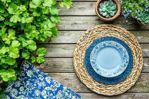 Summer Table Setting Blue and White Plates on Woven Placemats with Lush Greenery. photo