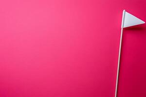 Minimalist Pink Background with a Small White Flag. A simple, clean image ideal for presentations or design projects. photo