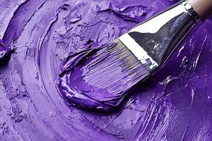 Close-up of a paintbrush applying rich purple acrylic paint, creating a textured and dynamic artistic effect. photo