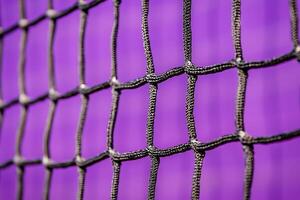 Close-up of Interwoven Netting Against a Vibrant Purple Background. photo