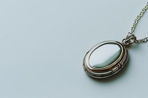 Elegant Oval Locket Pendant with Chain on Light Background. A close-up shot of a silver locket necklace perfect for showcasing jewelry or sentimental themes. photo