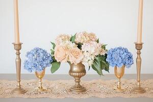 Elegant Table Setting with Gold Candle Holders, Hydrangeas, and Roses. photo