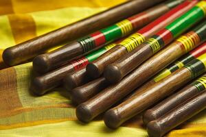 Close-up of Wooden Sticks with Colorful Accents Resting on Yellow Fabric. A detailed image showcasing the texture and vibrant colors. photo
