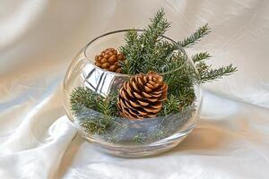 Festive Fir Branches and Pinecones in a Glass Bowl. A charming winter centerpiece or holiday decoration. photo