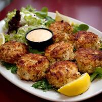 Delicious Crab Cakes with Fresh Salad and Dipping Sauce Presentation. photo