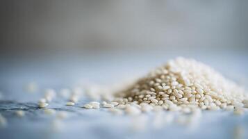 Close Up of White Sesame Seeds Scattered on a Marble Surface. photo