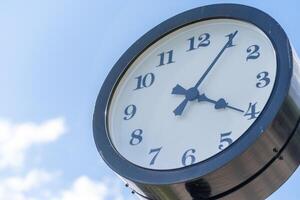 Clock Displaying Four Oclock Against a Clear Blue Sky With Scattered Clouds in a Park Setting During the Afternoon photo