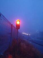 Warning Light Blinks Over Foggy Landscape as Visibility Diminishes Along the Roadway photo