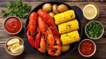 Delicious crawfish boil with corn on the cob, potatoes, and dipping sauces photo