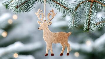 Wooden reindeer ornament hanging on snowy christmas tree branch photo