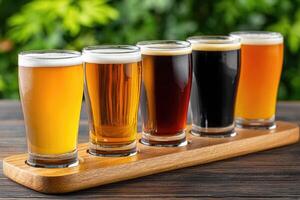 Wooden tray holding five glasses of different beers is standing on a table photo