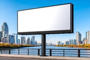 Large blank billboard by the river in urban setting with skyscrapers photo