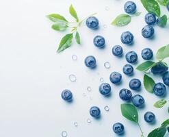 Fresh blueberries scattered on a light blue surface photo