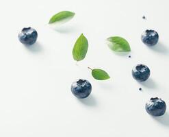 Fresh blueberries and leaves on white background photo