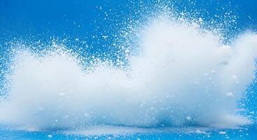A white liquid splashing on a blue background photo