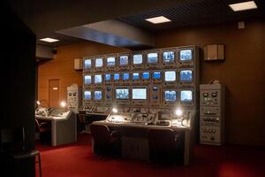 Control Room With Multiple Monitors and Vintage Equipment Illuminated in Low Light During a Late Night Session in an Operational Facility photo