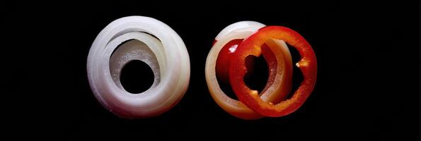 Floating Rings of Onion and Pepper Create a Minimalist Contrast Against a Dark Background With an Open Top Zone photo