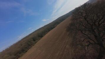 Close proximity FPV aerial view flying over rural fields and forests video