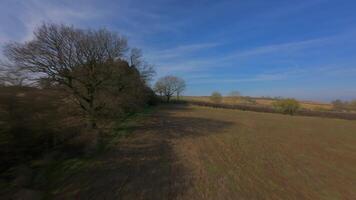 Aerial FPV drone flying fast over rural winter trees and farmland video
