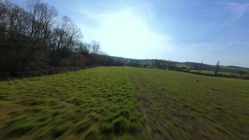 Speedy FPV drone flight through rural bare trees in spring landscape video