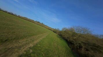 Dynamic close tree flying FPV drone over winter farmland England video