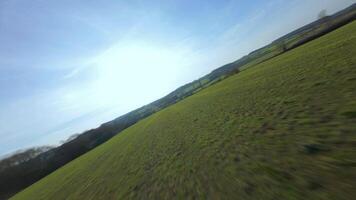 Fast FPV drone flying over rural farmland with winter trees and light video
