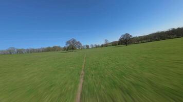 Immersive drone flight low over rural farmland in England UK video