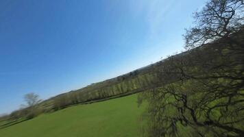 High speed FPV aerial drone over green farmland patchwork England video
