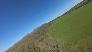 Aerial FPV drone close pass over fields and farmland England video