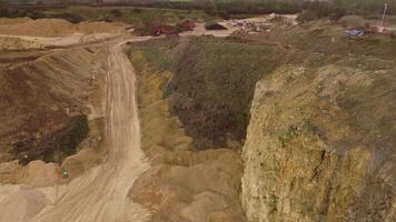 Aerial drone view over large open quarry mining operation with heavy machinery in England video
