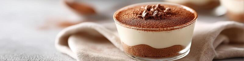 Classic Italian tiramisu served in a glass dish with cocoa powder dusting photo