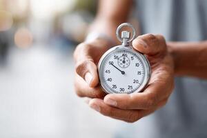 Hands hold a sleek stopwatch in a bright outdoor setting with ample copy space for promotion photo