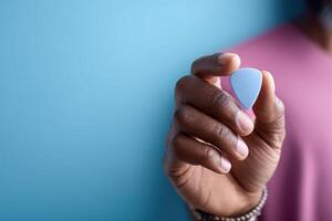 Stylish guitar pick held confidently against a vibrant blue backdrop with empty space for text placement photo