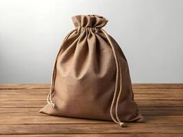 Brown Burlap Sack on Wooden Table Against White Background photo