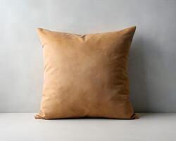 Tan Suede Square Pillow on White Surface Against a Textured White Wall photo