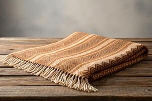 Brown and Beige Woven Throw Blanket on Rustic Wooden Table photo