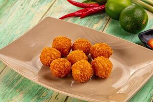 A plate of fried balls of food on a table photo