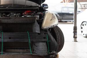 A car with its front end damaged and its engine removed photo