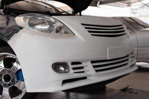 A white car is being worked on by a mechanic photo