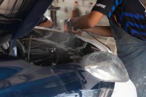 A man is working on a car in a garage photo