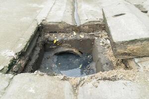 A hole in the ground with a pipe coming out of it photo